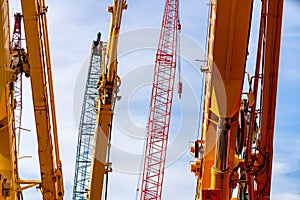 Selective focus on crawler crane against blue sky. Real estate industry. Red crawler crane use reel lift up equipment in