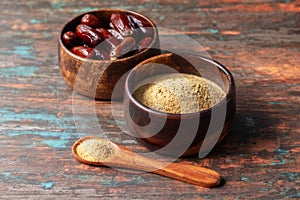 selective focus of dates with dates sugar on wooden bowls.