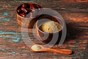 selective focus of dates with dates sugar on wooden bowls.