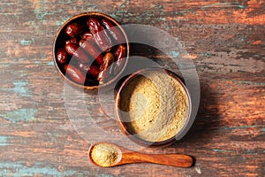 selective focus of dates with dates sugar on wooden bowls.