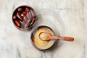 selective focus of dates with dates sugar on wooden bowls.