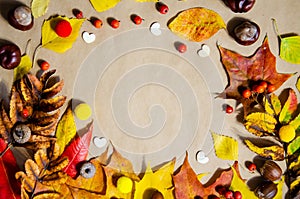 Selective focus decorative wooden hearts, yellow, red, green, brown autumn leaves, chestnuts, rowan, acorns on beige wooden