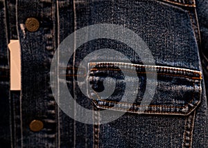 Selective focus on denim jean jacket pocket in clothes shop. Denim jacket pocket texture background. Textile industry. Jeans