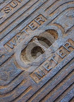 A detail of an old steel water meter cover dug out of the ground photo