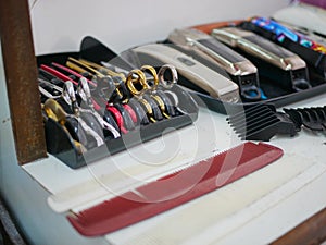 Selective focus of different colors of hair scissors placed on a table ready to be used in a hair salon / barber shop