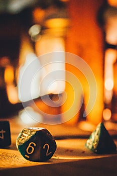 Selective focus of dnd dice set in warm lights on a blurry background