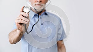 Selective focus on doctor hand holding stethoscope