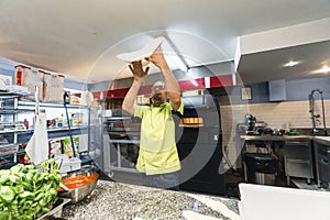 selective focus on the dough that the chef throws up the air. Process of making a pizza base