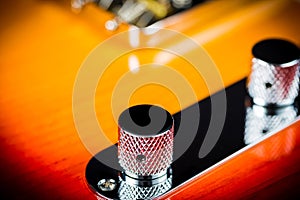 Selective focus of electric guitar volume knob on blurred background