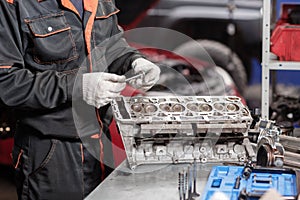 Selective focus. Engine Block on a repair stand with Piston and Connecting Rod of Automotive technology. Blurred red car