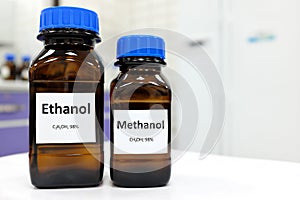 Selective focus of ethanol and methanol in brown glass bottle container. White laboratory background with copy space.