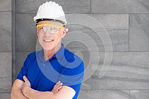 Selective focus at face of Caucasian foreman at building construction site, wearing protective hat and safety equipment while