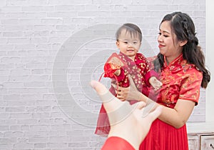 Selective focus father hand provide envelop angpao for kid adorable baby on Chinese New year Traditional  Chinese family spent