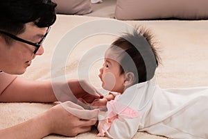 Selective focus father and healthy newborn 3 months baby eye contact together on bed, happy dad spent time talk to daughter at