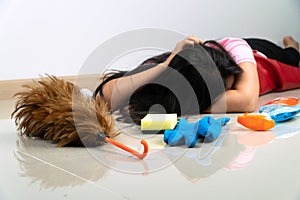 Selective focus of Feather duster.Asian housewives lie on the floor due to fatigue from household chores. With various cleaning eq