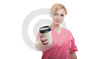 Selective focus of female nurse wearing pink scrubs holding coffee