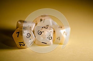 Selective focus, five 12-sided white dice on yellow background dice for role-playing games