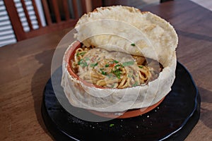 Selective focus of a flat bread stuffed with spaghetti pasta with greens and cheese