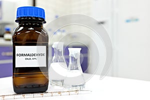 Selective focus of formaldehyde or formalin in brown amber glass bottle inside a laboratory.