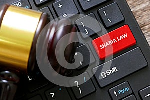 Selective focus of a gavel and a keyboard with red button written with Sharia Law photo