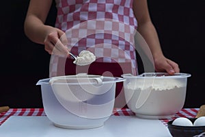 Selective focus. Girl  sifting flour adding baking ingredients. Home bakery