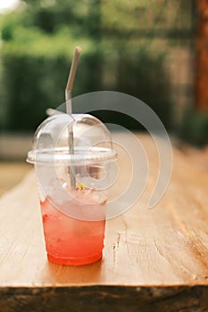 Selective focus, The glass of strawberry iced soda on wooden table. Cuba Libre or long island iced tea cocktail, cold drink or