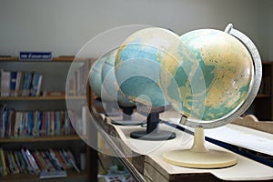 Selective focus globe model simulation with bookshelf background