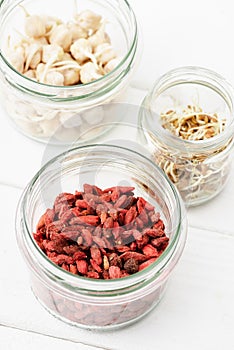 Selective focus of goji berries and sprouts in glass jars