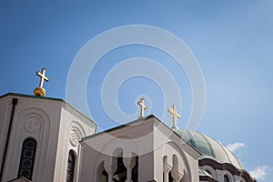 Selective focus on golden christian orthodox crosses on the Saint Sava Cathedral Temple Hram Svetog Save with the mala crkva sve