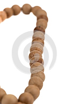 Selective focus on grains of rosary over a white background.