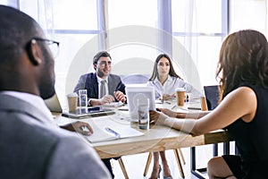 selective focus of group of multiethnic business colleagues discussing strategy during business meeting