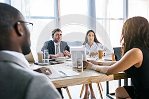 selective focus of group of multiethnic business colleagues discussing strategy during business meeting