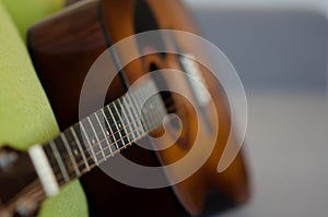 Selective focus guitar fretboard with strings on blurred gray background with copy space. Music concept. Guitar neck texture. Gray