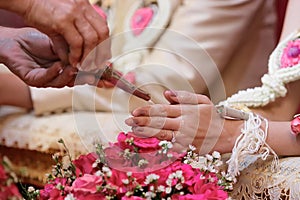 Selective focus on hands of bride and groom in water relaunch ceremony. Thai traditional wedding
