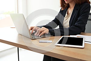 Selective focus on hands of business woman working with laptop on the workplace in office