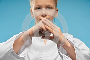 Selective focus of hands of girl showing fist in studio