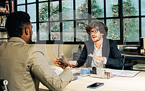 Selective focus handsome businessman seriously discussing with argument, disputing while sitting in modern meeting room at office