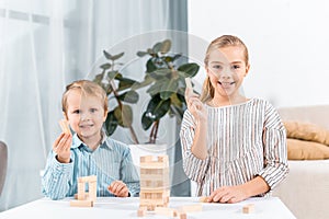 selective focus of happy adorable children playing blocks wood tower game