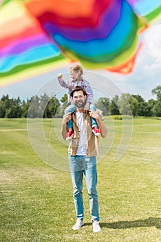 selective focus of happy father and daughter playing with colorful kite
