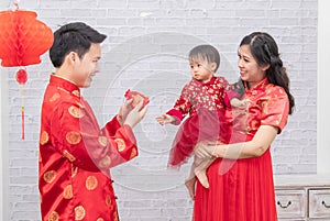 Selective focus on happy father provide envelop angpao for kid baby on Chinese New year Traditional  Chinese family spent time