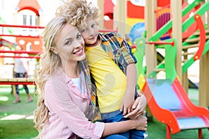 selective focus of happy mother embracing curly little son