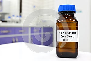 Selective focus of high-fructose corn syrup or hfcs food and beverage sweetener in dark brown glass bottle inside a laboratory.