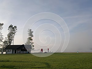 Selective focus of a house on a green field with trees in a rural area