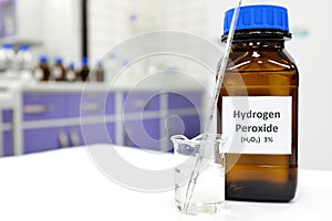 Selective focus of hydrogen peroxide solution in brown amber bottle. Blur laboratory background with copy space. photo