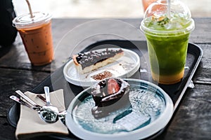 Selective focus of ice matcha green tea and cake on wooden plate. Drink that is sugar-free and homemade Food and baverage