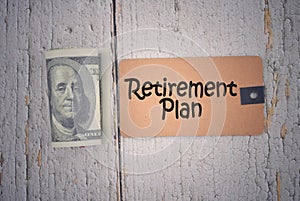 Selective focus image of banknote  US dollar with retirement plan wording on a wooden background. Business and economy concept