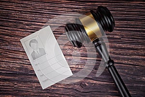 Selective focus image of gavel with identification card isolated over a wooden background. Law concept