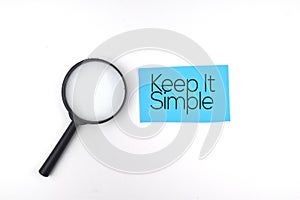 Selective focus image of magnifying glass with Keep It Simple wording on a white background. Life and motivational concept