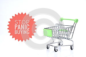 Selective focus image of trolley cart with Stop Panic Buying wording isolated in white background. Economy and buy sell concept