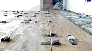 Selective focus. Installing ceramic floor tiles.  Installing on floor a ceramic tile at repair renovation work